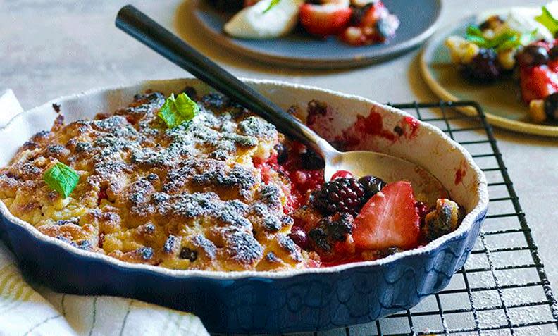 Grillet smuldrepai med bjørnebær og jordbær, i mørkeblå paiform. Melis strødd på toppen, og pyntet med et par blader sitronmelisse. Skje stukket ned i formen.