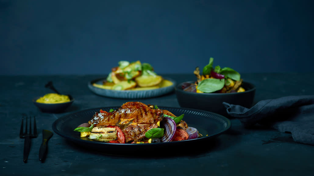 Grilet kjøtt på tallerken med tilbehør rundt