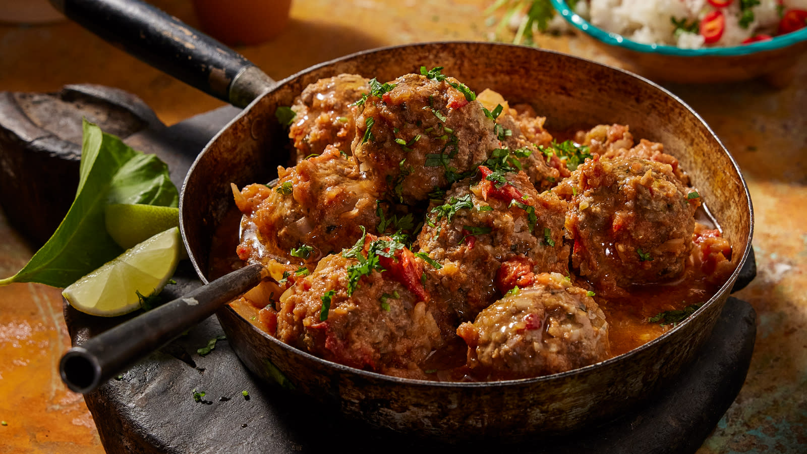 Albondigas Mexicanas - Meksikanske kjøttboller i tomatsaus servert i metallkjele på mørk trefjøl.