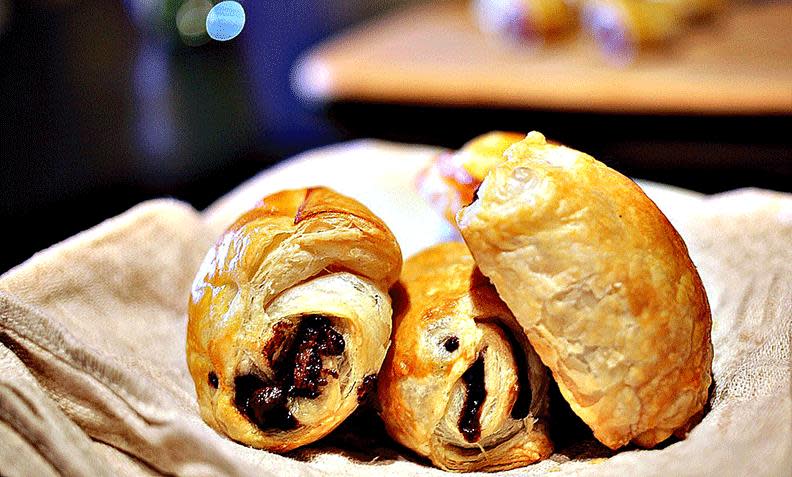 Pain au chocolat, fransk bakverk av butterdeig og sjokolade, servert på beige linduk.