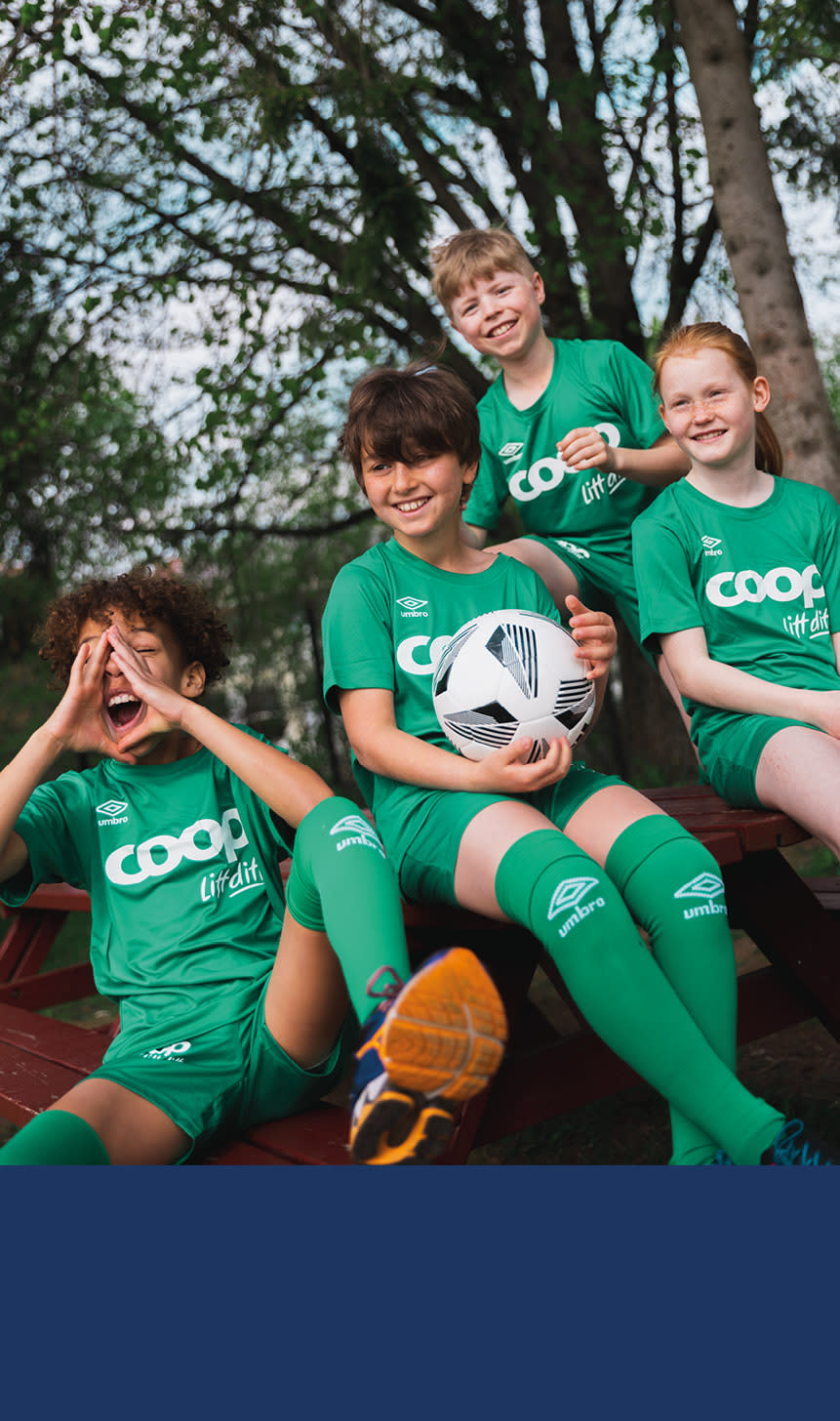 Flere barn i grønne coop fotballdrakter.