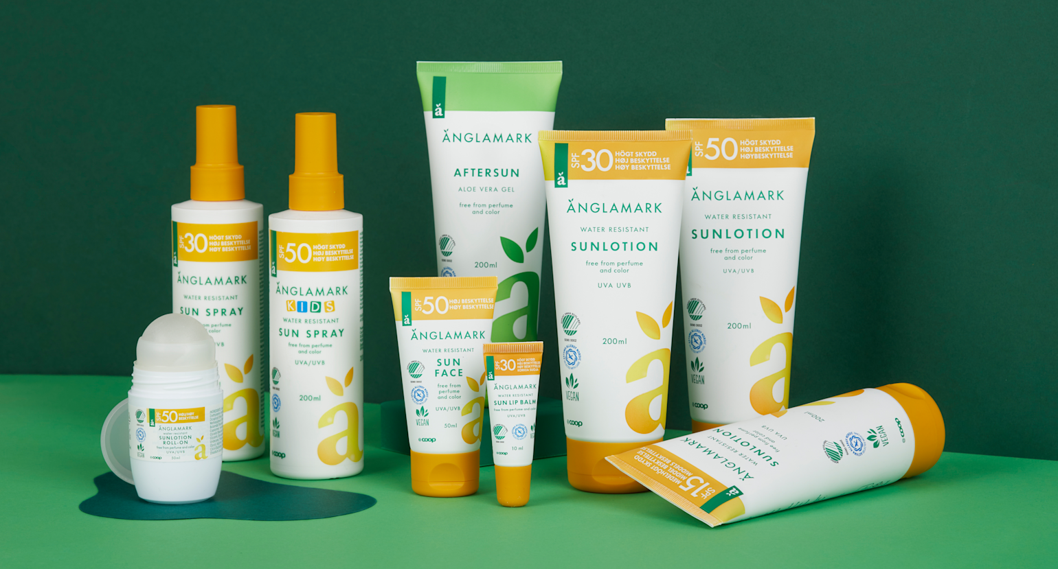 Bildet viser et bredt utvalg av solpleieprodukter fra Änglamark, presentert mot en grønn bakgrunn som fremhever merkets naturlige profil. Produktene inkluderer vannresistente solsprayer, solkremer, aftersun, roll-on solkrem, ansiktskrem og solstift for lepper – alle merket med ulike solfaktor-nivåer fra SPF 15 til SPF 50. Emballasjen er preget av et rent, hvitt design med grønne og gule detaljer og tydelige symboler for UVA/UVB-beskyttelse, vegansk innhold og parfymefri formulering. Produktene er spesielt utviklet for sensitiv hud og barn, og reflekterer Änglamarks fokus på miljøvennlighet og allergivennlige ingredienser.