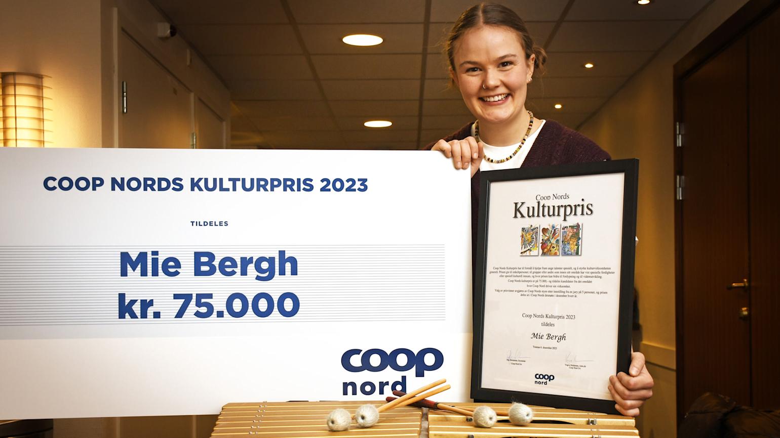 Mie Bergh viser frem sjekk og bevis på at hun har vunnet prisen