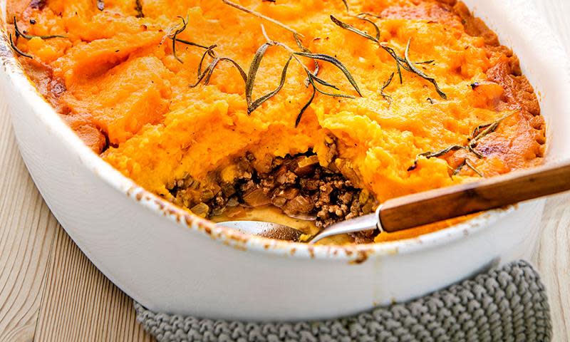 Shepherd's pie med oransje søtpotetlokk, i hvit ildfast form. Serveringsskje i formen.