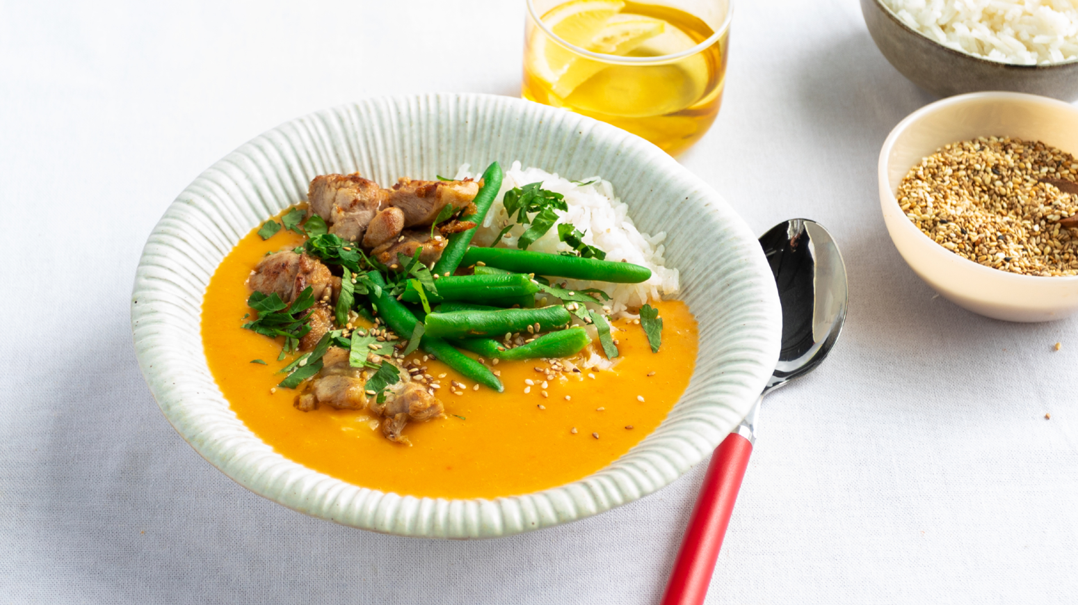 Thaisuppe med kylling, grønnsaker og koriander, i en hvit skål