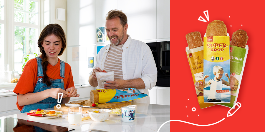 Smilende far far og datter ståt på et hvitt kjøkken og smører seg brødskiver