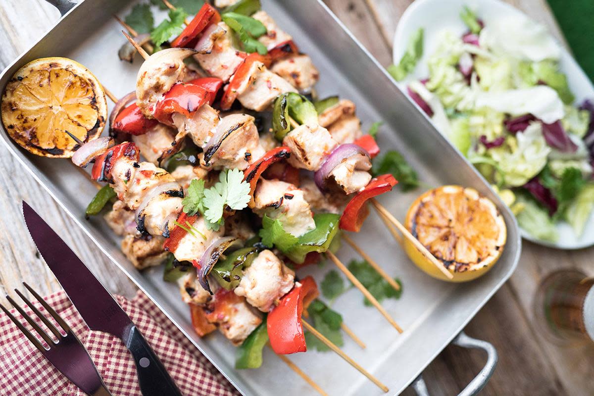 Grillede kyllingspyd med rød og grønn paprika, fersk koriander og hjemmelaget ingefær- og chilimarinade. Servert i ildfast form med grillede sitroner.