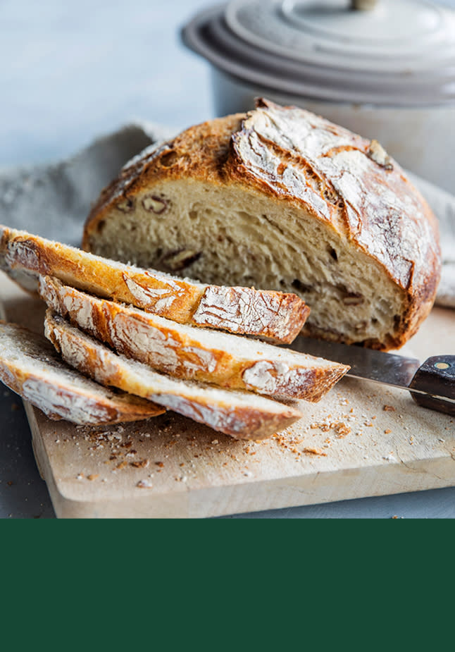 Eltefritt brød på en fjøl. Et par skiver er skåret opp. 