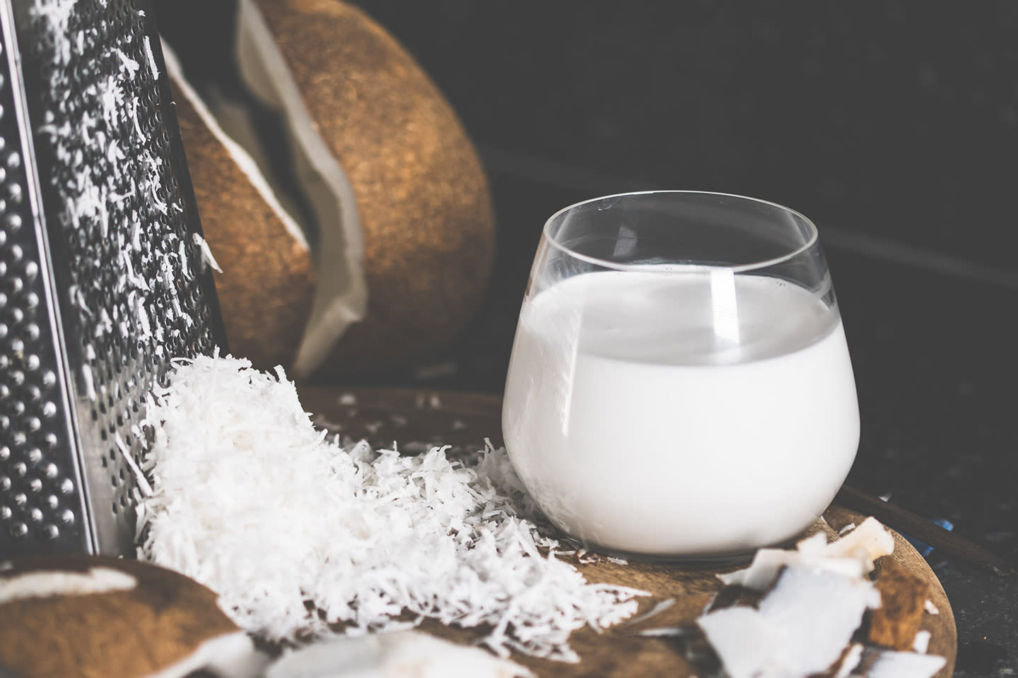 Kokosmelk i glass og raspet kokosmasse på fjøl