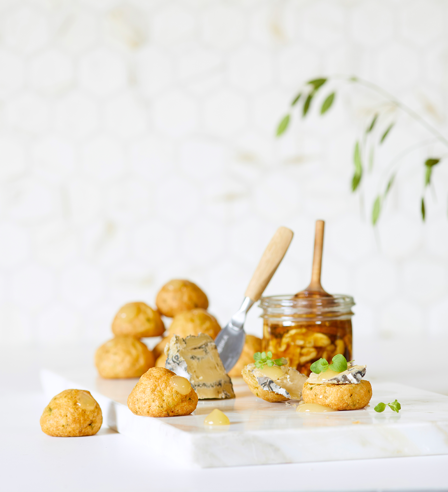 Vannbakkels med persille, fylt med eplemarmelade. Servert på bord med blåmuggost og honning ved siden av.