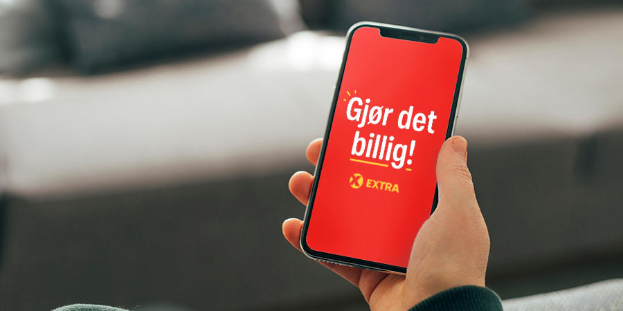 Hånd holder mobil med Gjør det billig Extra logo