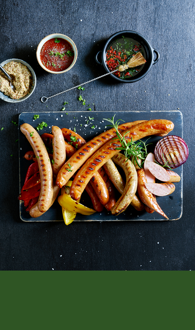 Pølser på sort fat øverst og grønn bakgrunn nederst