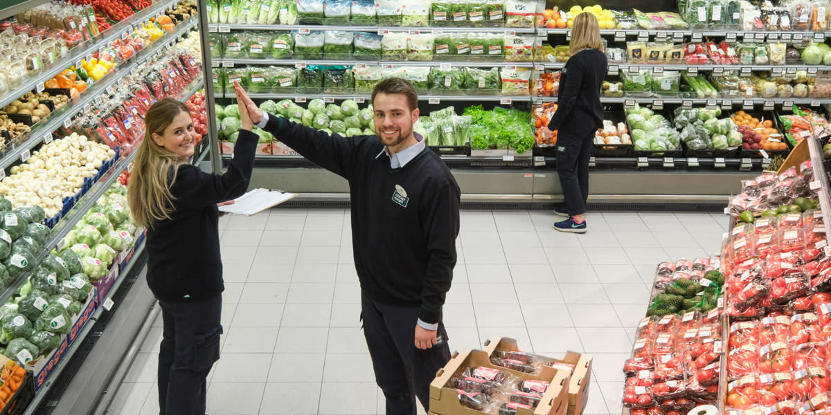 To Coop Mega ansatte tar high five i fukt og grønt avdelingen
