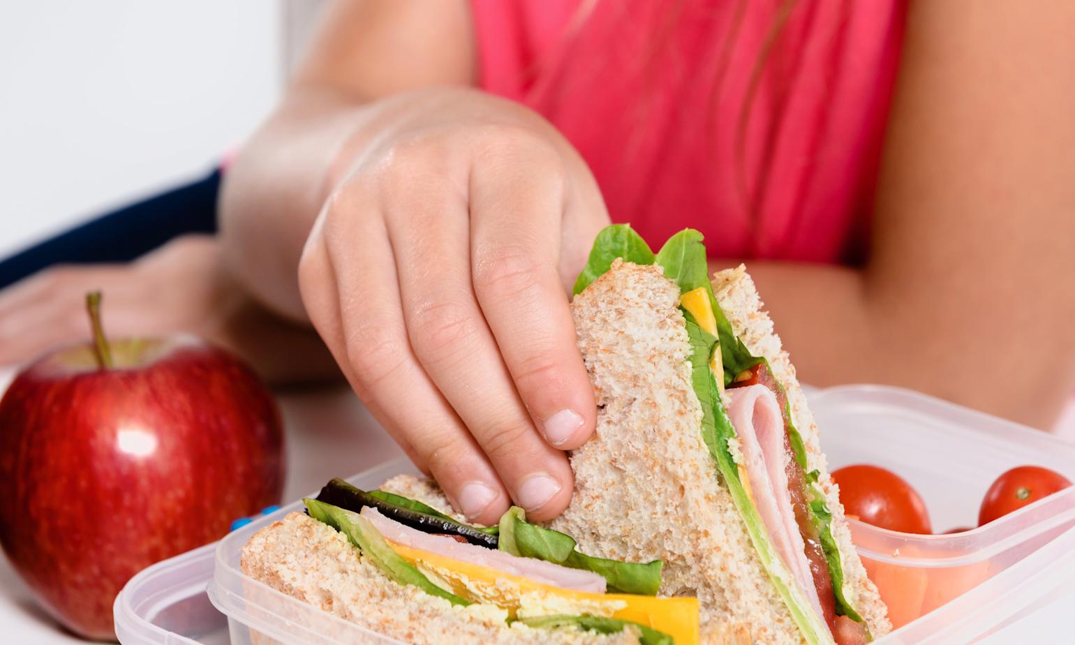Jente forsyner seg av fristende mat i matboks