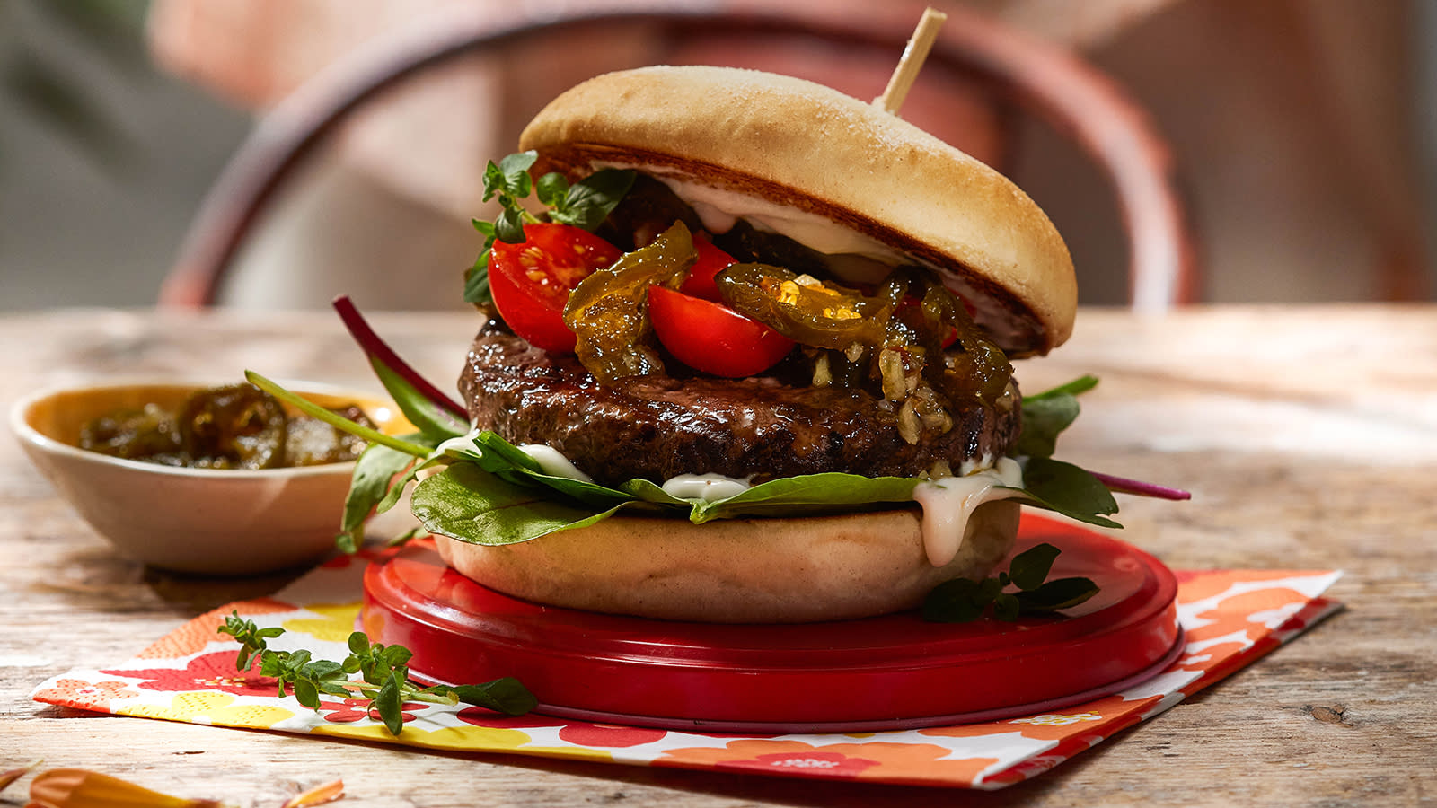 Burger med Cowboy candy servert på rødt lokk med piccolotomater, babyleaf og aioli.