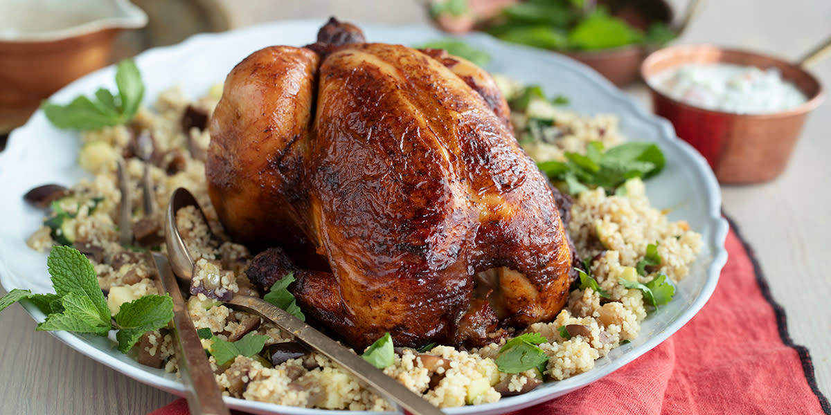 Helstekt kylling på en seng av couscous med raita ved siden av