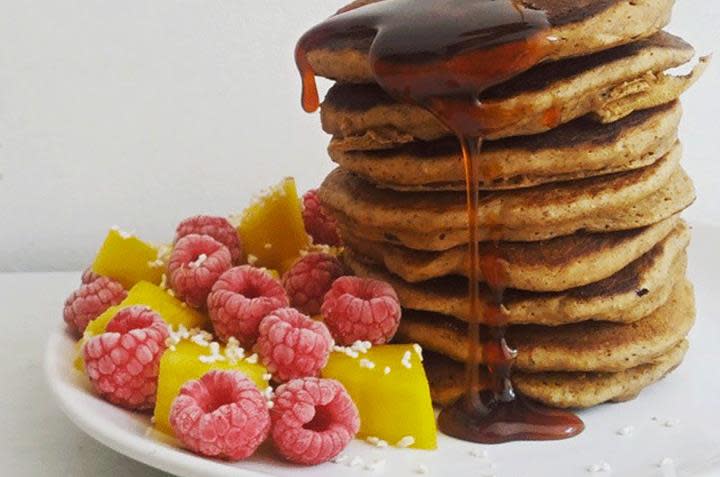 Havrelapper med banan stablet i tårn, og servert med bringebær, mango og lønnesirup.