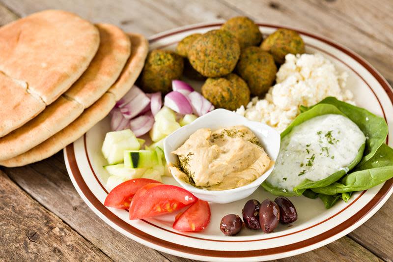 Middagstallerken med falafel, oliven, tomat, agurk, rødløk, hummus og pitabrød.