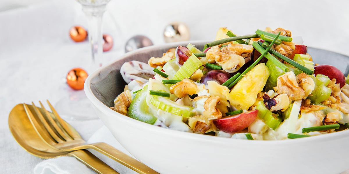 Stor bolle med waldorfsalat med valnøtter, druer, hakkede urter og selleristang.