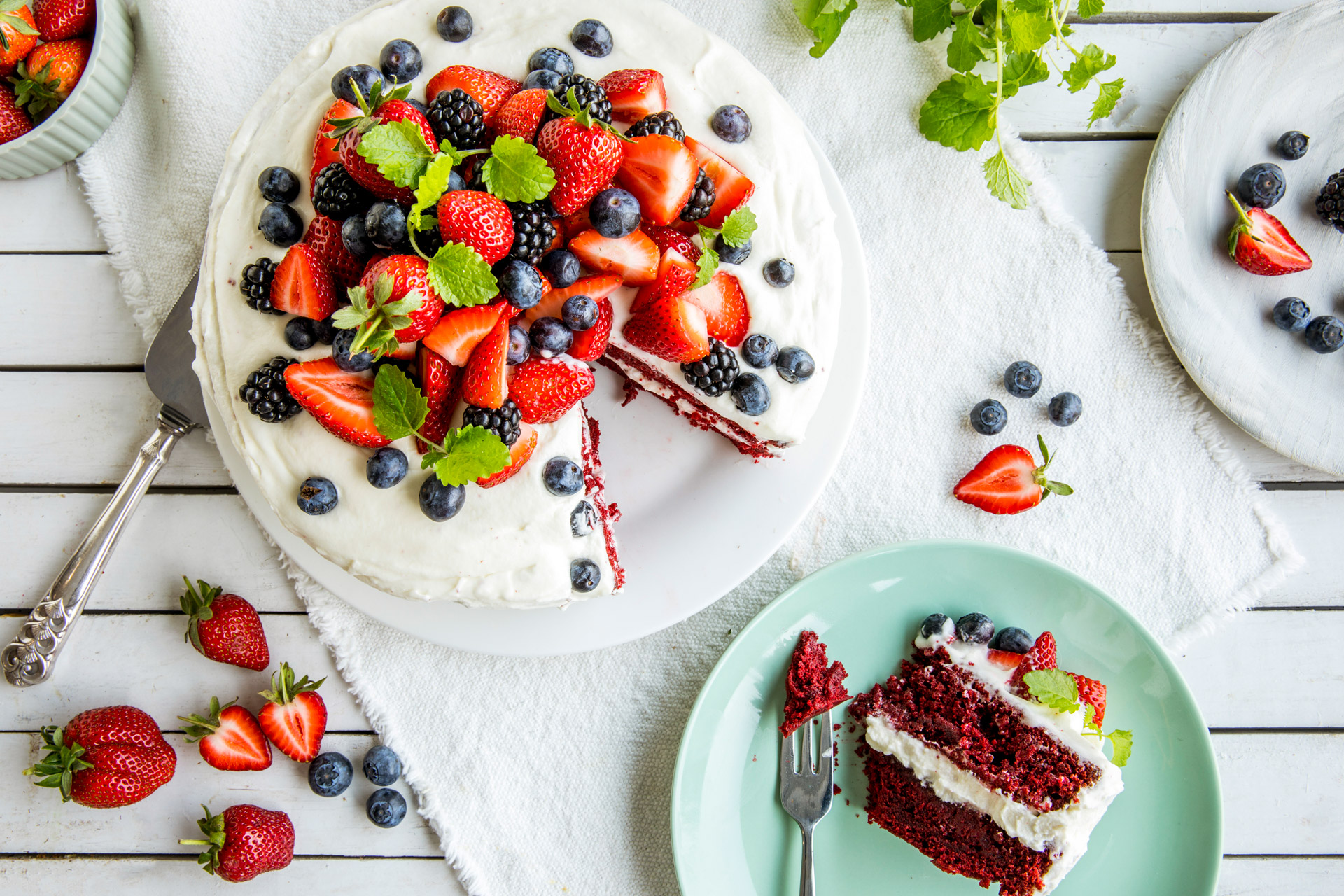 Red velvet kake på et fat pyntet med hvite bær.