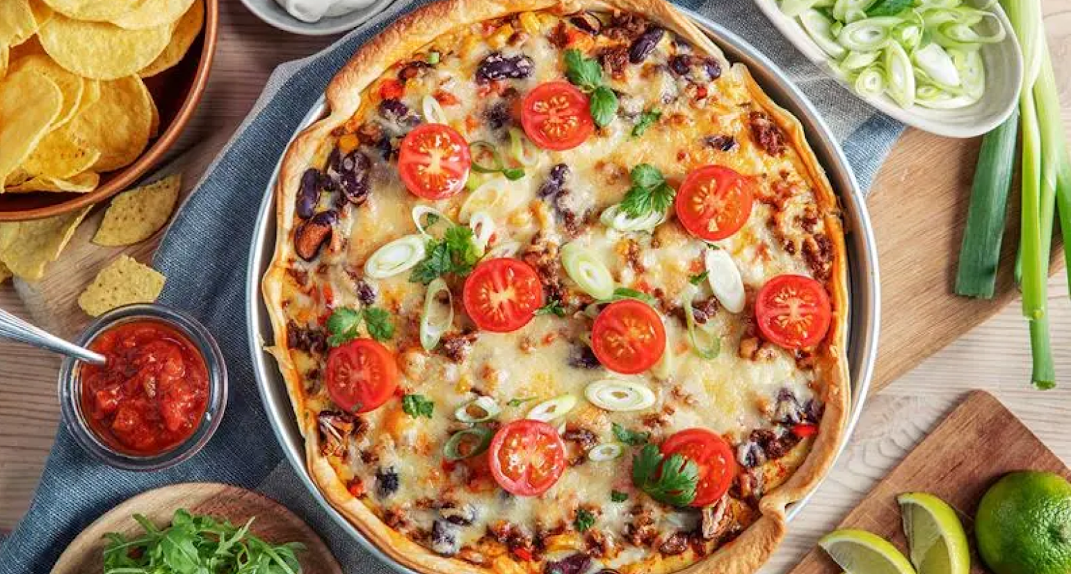 Bilde av en pai med masse grønnsaker rundt.