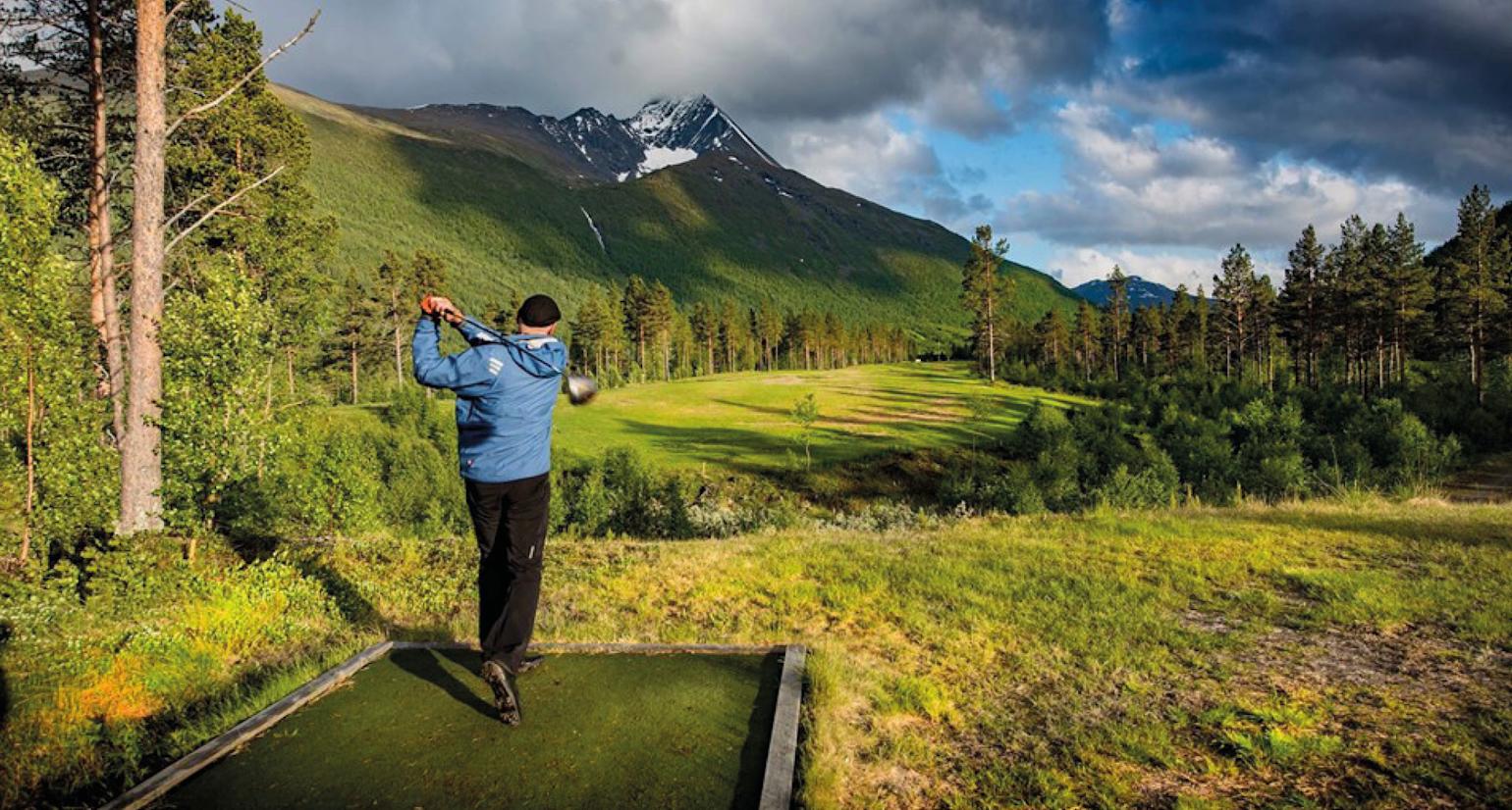 Mann som spiller golf i flott natur.