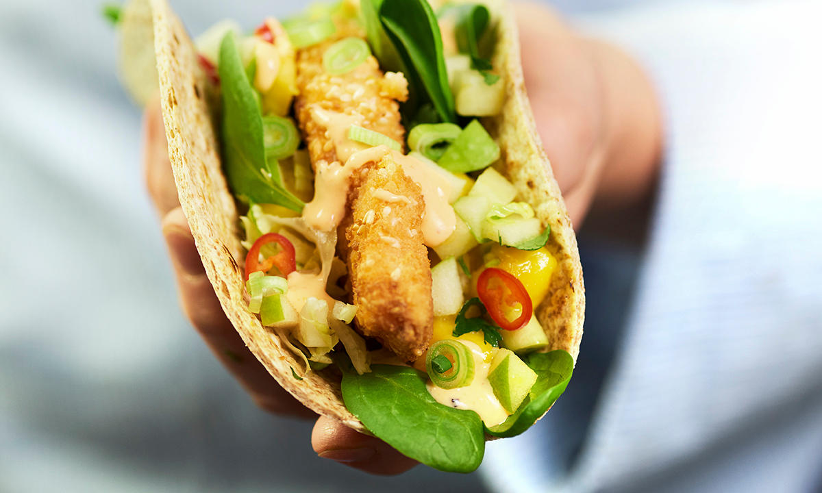 Sprøpanert laks med småblads-salat, eple, mango, agurk, chili og sriracha-majones i en wrap.