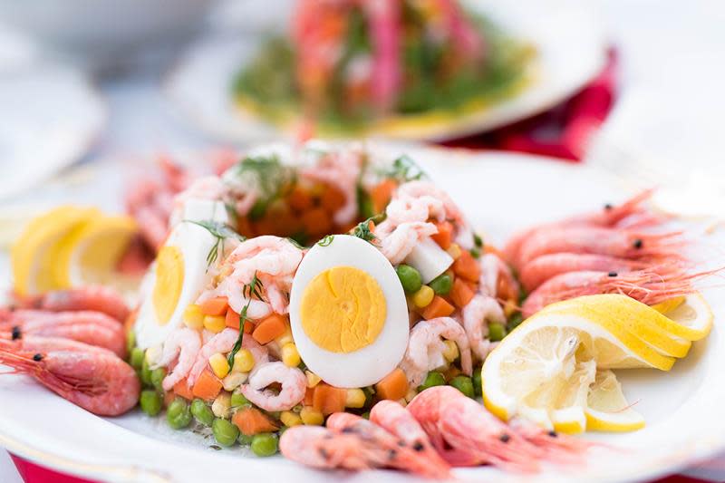 Hjemmelaget fargerik kabaret med erter, mais, reker, gulrot og kokt egg. Servert på hvitt fat med hele reker.