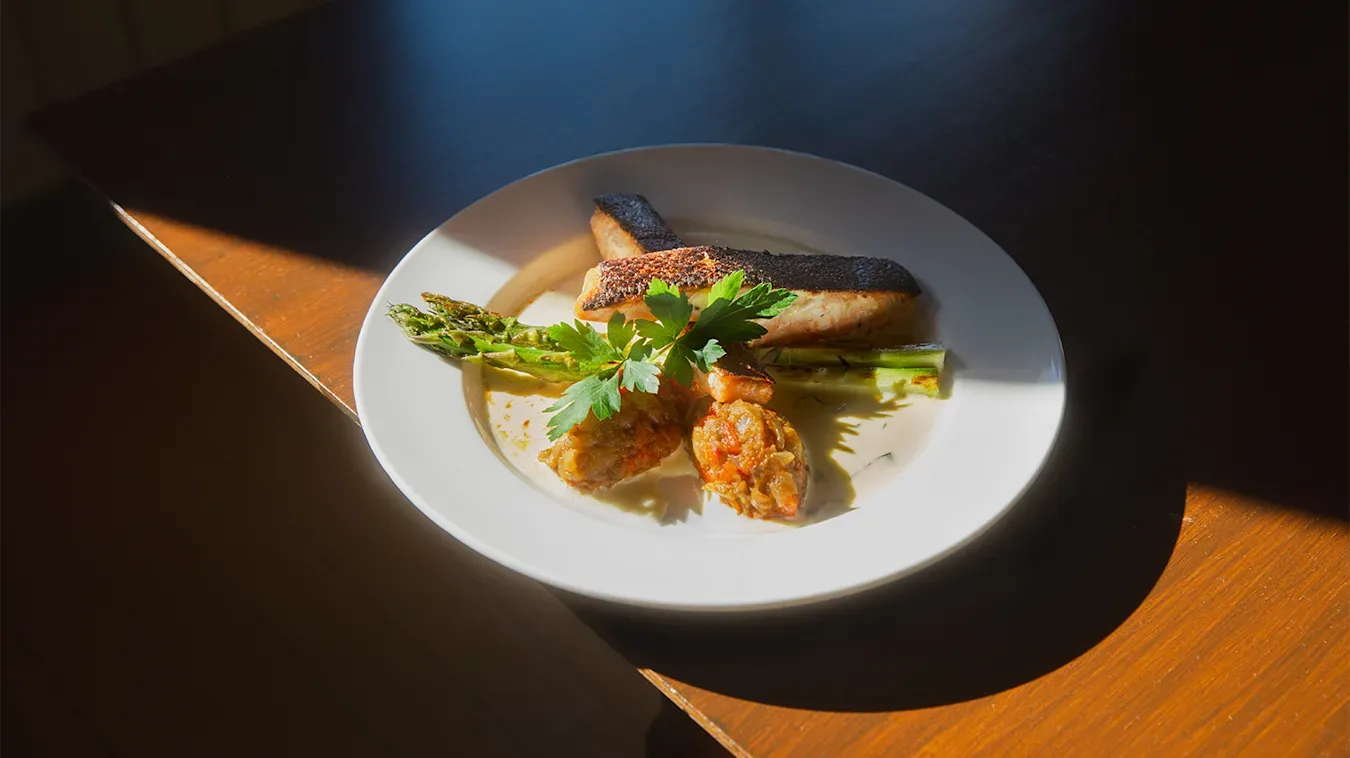 Grillet laks med estragon på tallerken på trebord