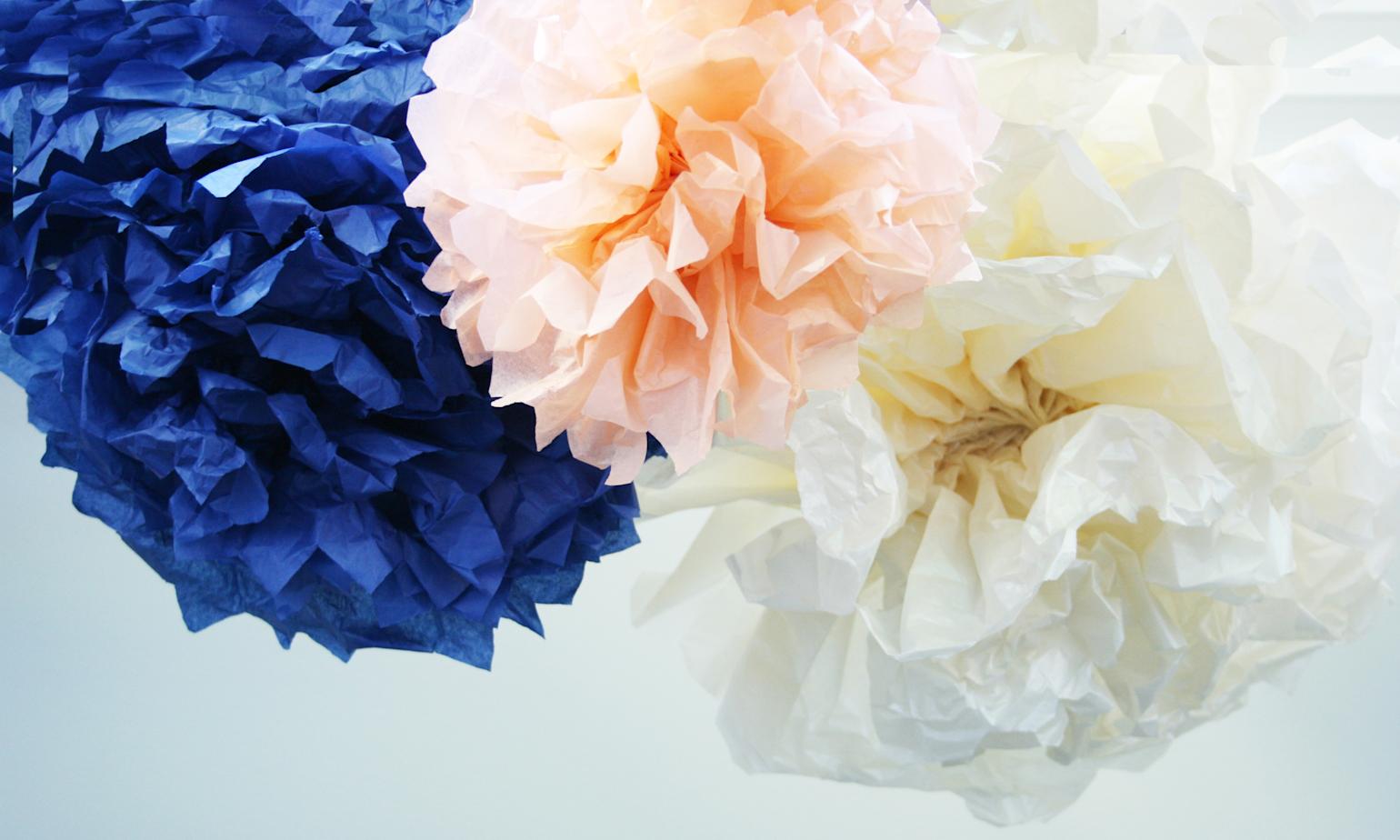 Hjemmelagede pom-poms i blått, rosa og hvitt