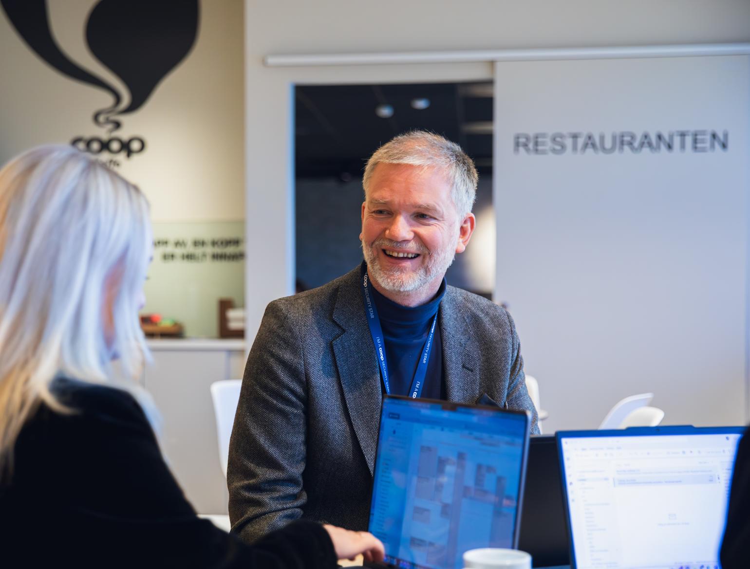 Mann som smiler i kaffebaren