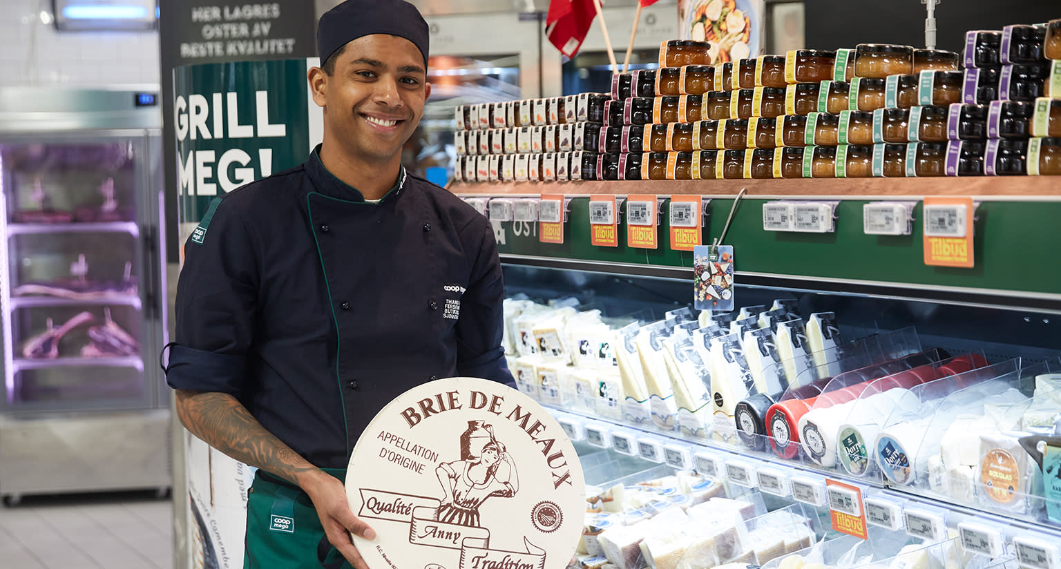Coop Mega ansatt viser frem stort ostehjul