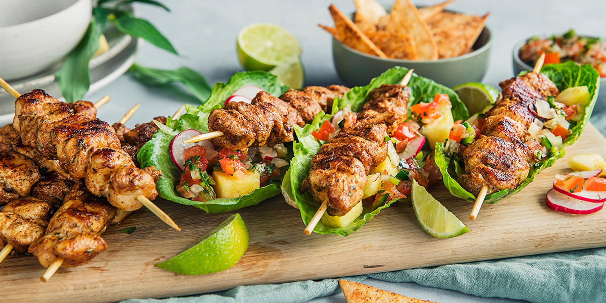 Meksikanske grillspyd på fjøl med tilbehør rundt