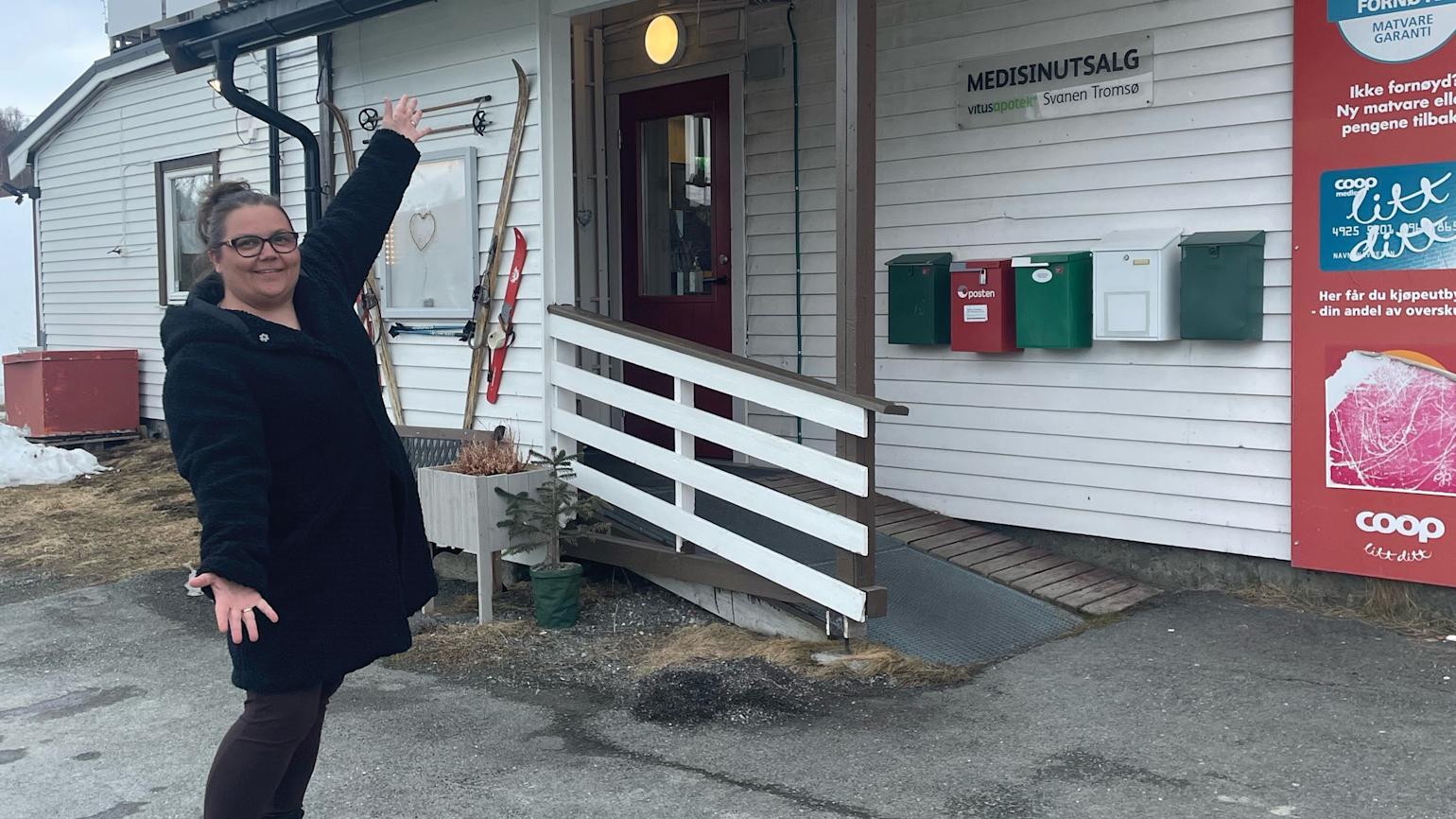 Stolt dame viser frem butikken sin.