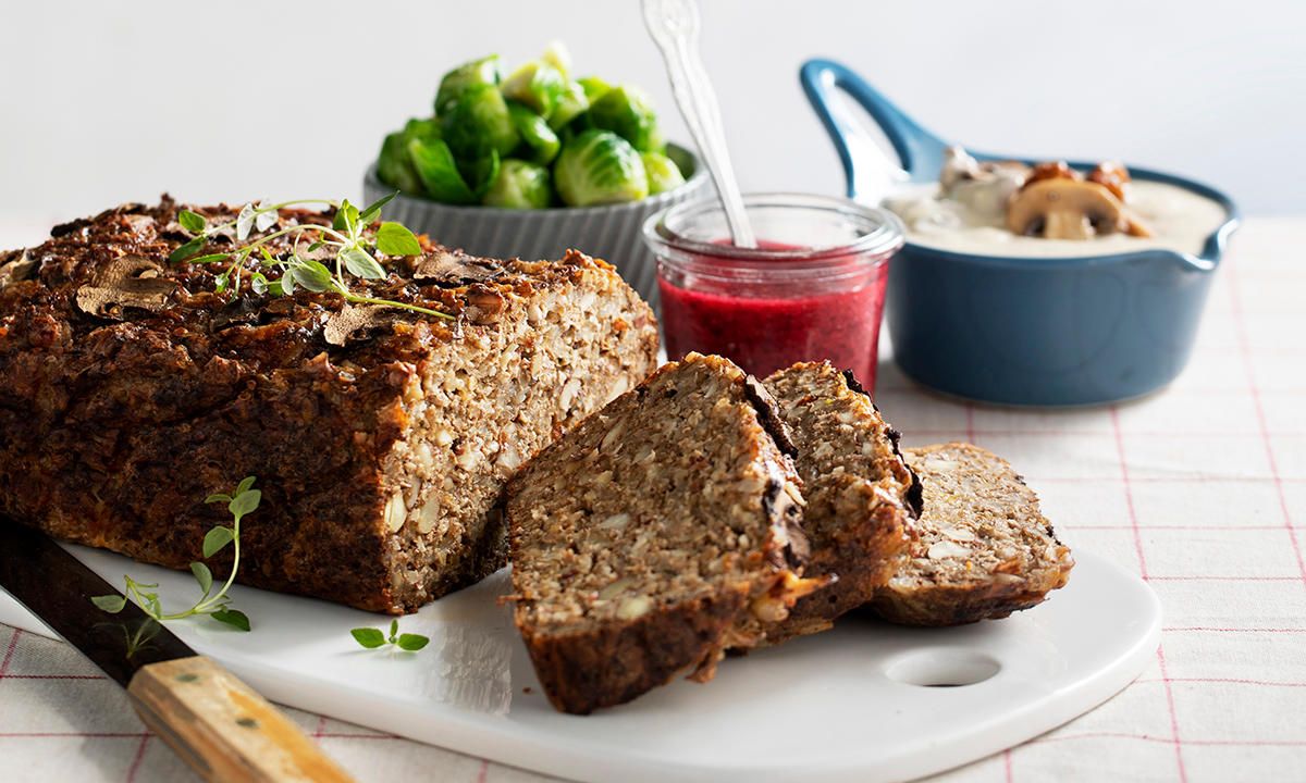Nøttestek - julens vegetarfavoritt, servert på hvit marmorfjøl med dampet rosenkål og soppsaus.