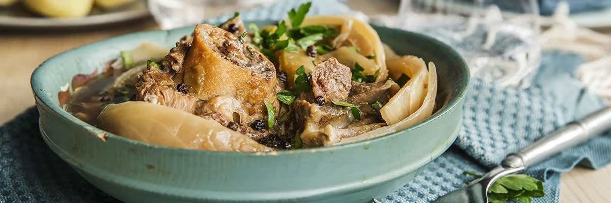 Fårikål i en blå skål på et dekket bord