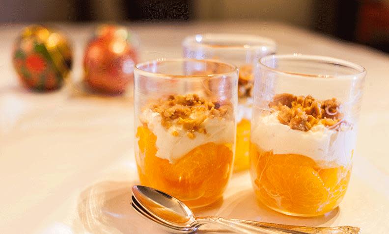 Mascarponekrem med klementiner og salt peanøttkrokan servert i glass på dekket julebord med hvit duk.