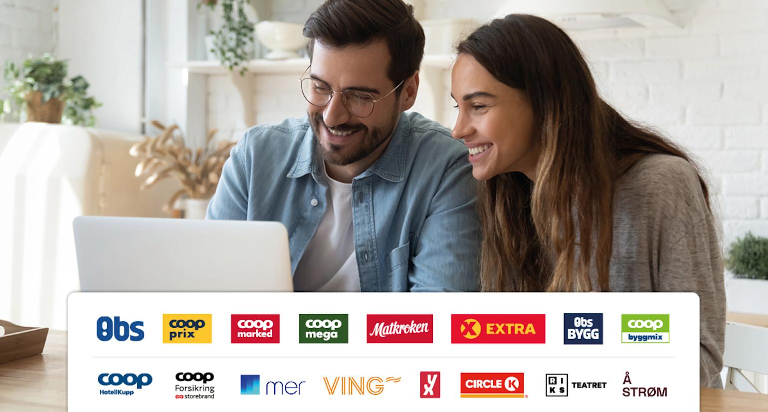 Et par ser på en dataskjerm og smiler.