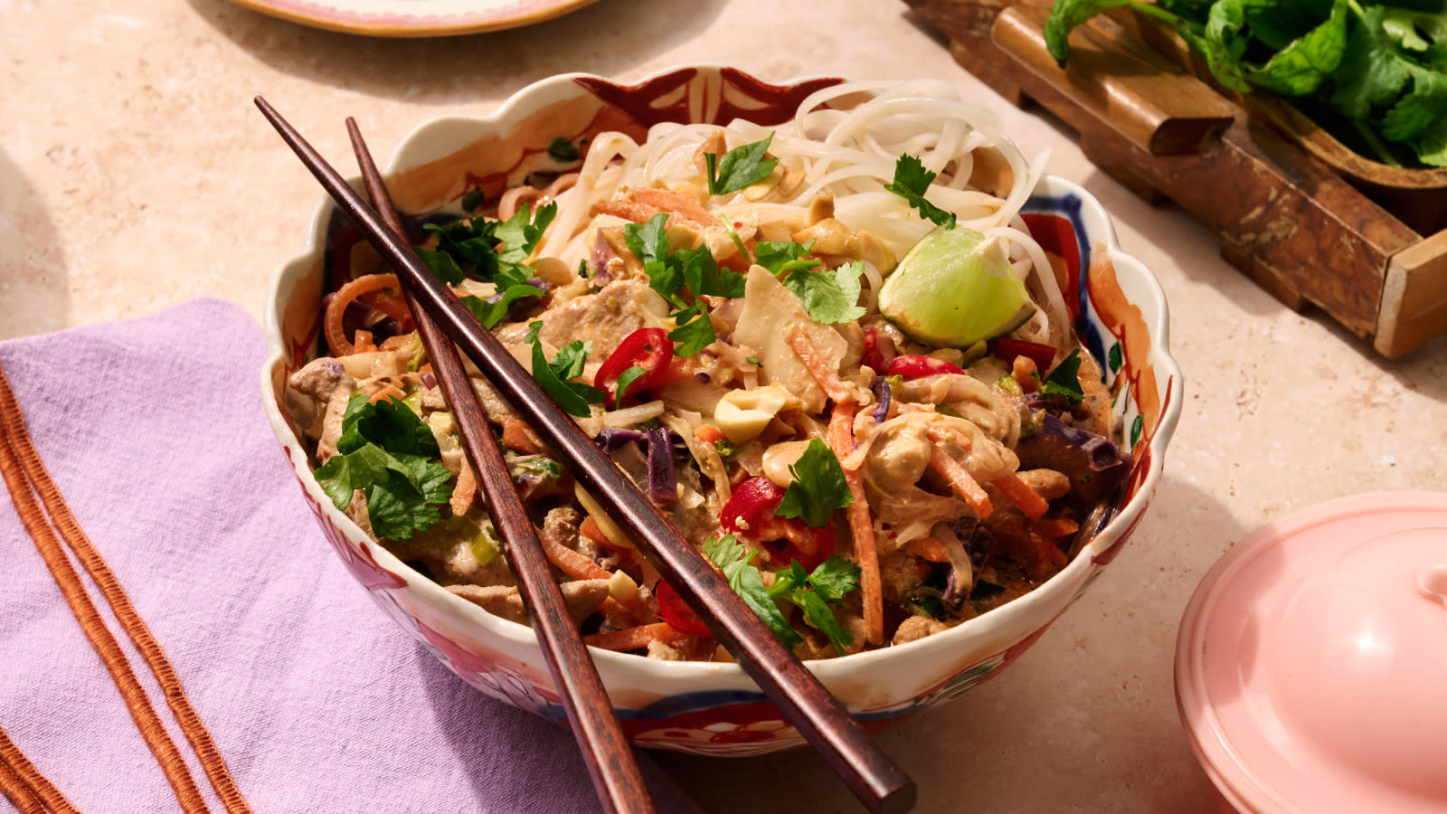 Curry in a hurry med Coop Wokmiks Red Curry, frisk chili, koriander og limebåt servert med risnudler i mønstret bolle.