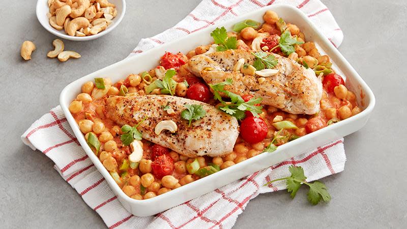 Kyllingform er kyllingfilet med kikerter og kokosmelk, cherrytomater og cashewnøtter. Formen står på rødt og hvitt kjøkkenhåndkle.