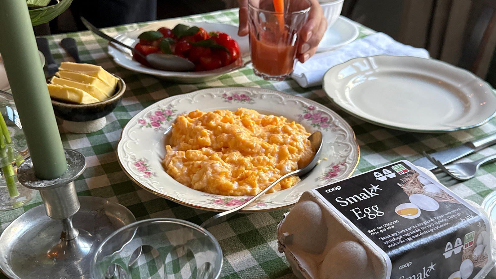 Eggerøre à la Sultne Gutter servert i rosemalt hvit skål på dekket frokostbord med grønnrutet duk. Smak eggekartong på siden.