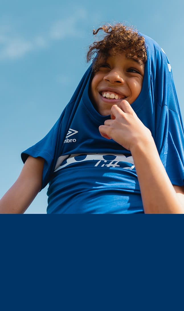 Gutt smiler i Coop-drakt