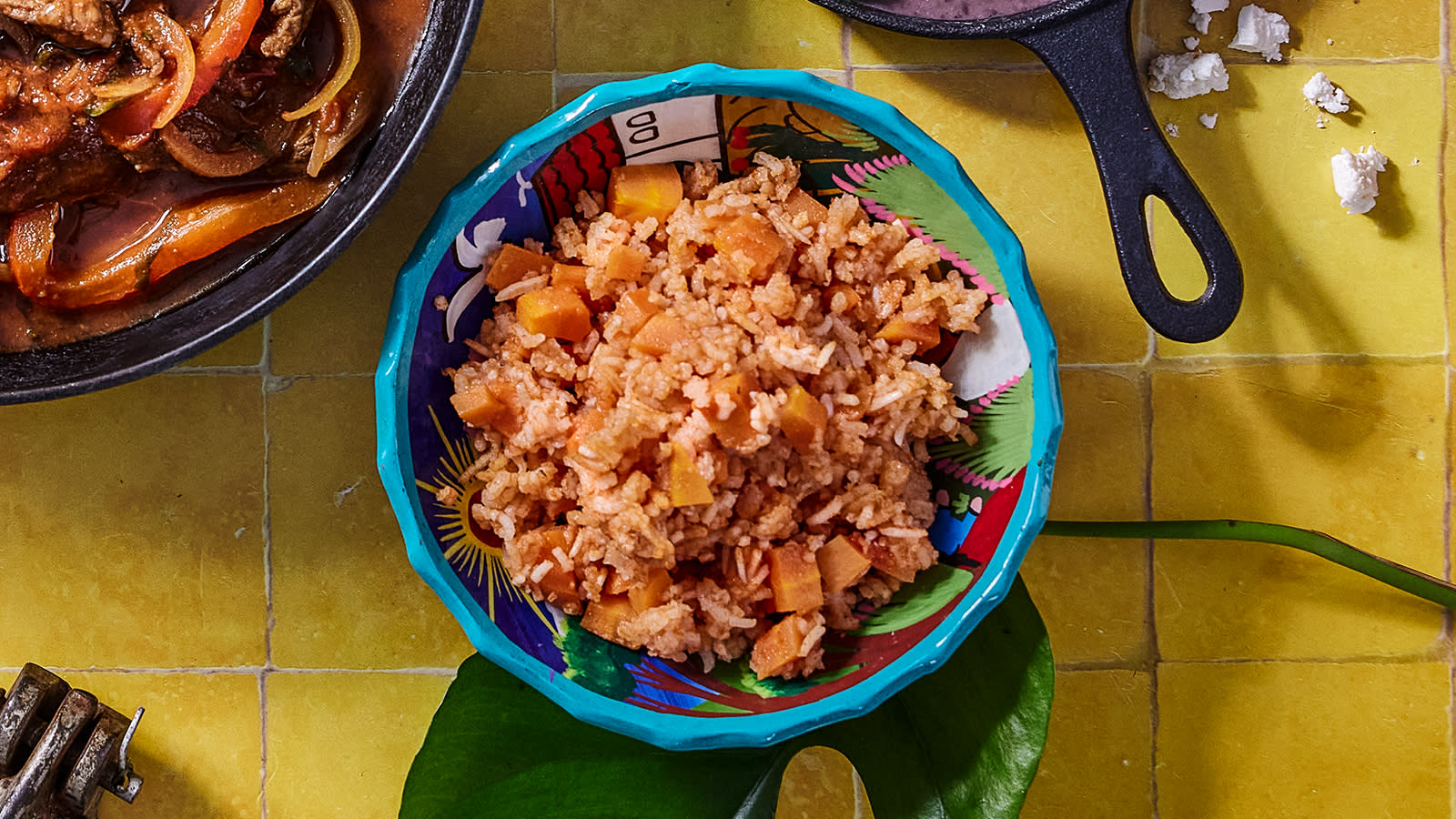 Meksikansk ris med gulrot servert i fargerik bolle på gule fliser.