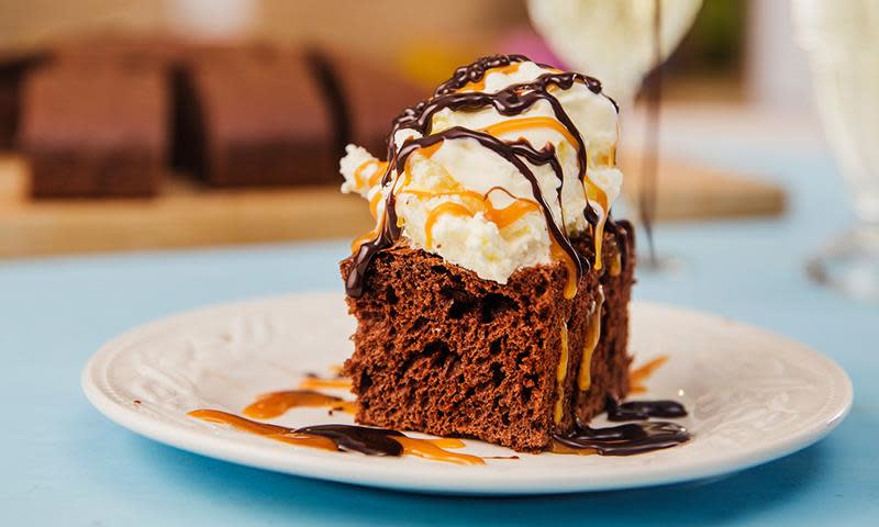 Chocolate cola cake - luftig sjokoladekake i langpanne, laget med kun 2 ingredienser, Toro kakemiks og cola. Stykke servert på hvit tallerken med iskrem, sjokolade- og karamellsaus.