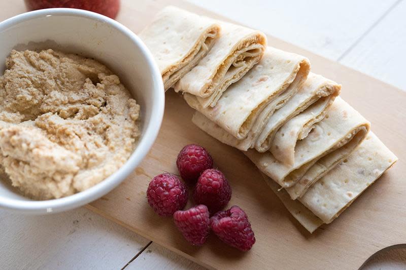 Hjemmelaget gomme servert i en liten skål på en trefjøl. Påsmurt lefse med gomme, og bringebær ved siden av.