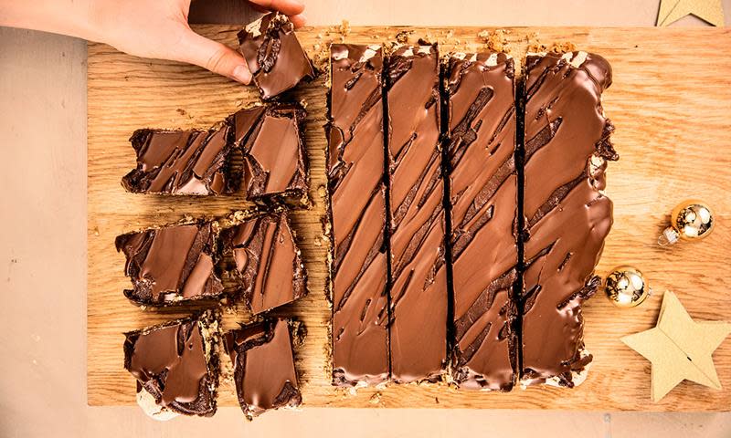 Kaken Sarah Bernhardt i langpanne, delt i biter og lagt på trefjøl. Gulllfarget julestjerne og julekule på siden.