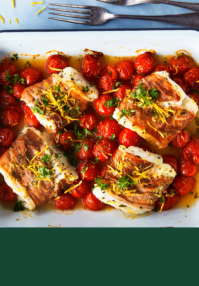 Hvit fisk surret i bacon, i en form med tomater.