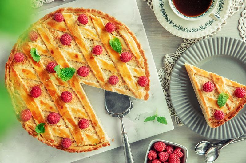 God gammeldags fyrstekake pyntet med friske bringebær og sitronmelisse, og servert på marmorfat på dekket kaffebord.