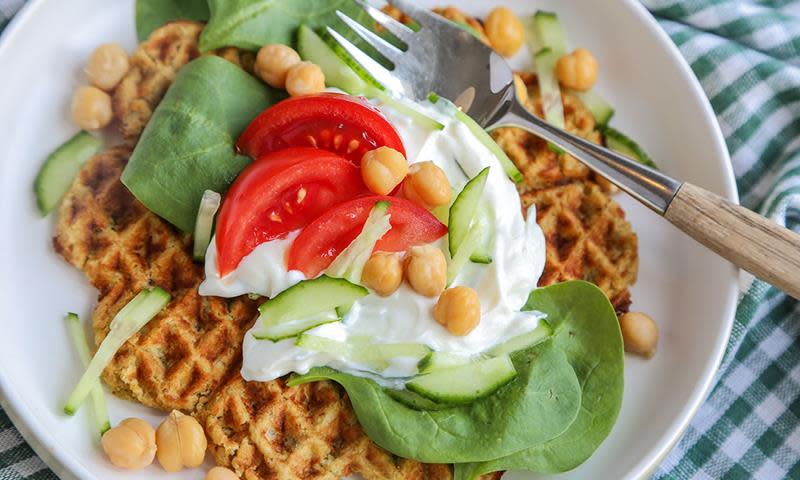Falafel vaffel, vafler laget med kikerter og krydder, servert med yoghurt naturelle, spinat, tomater, agurk og kikerter.