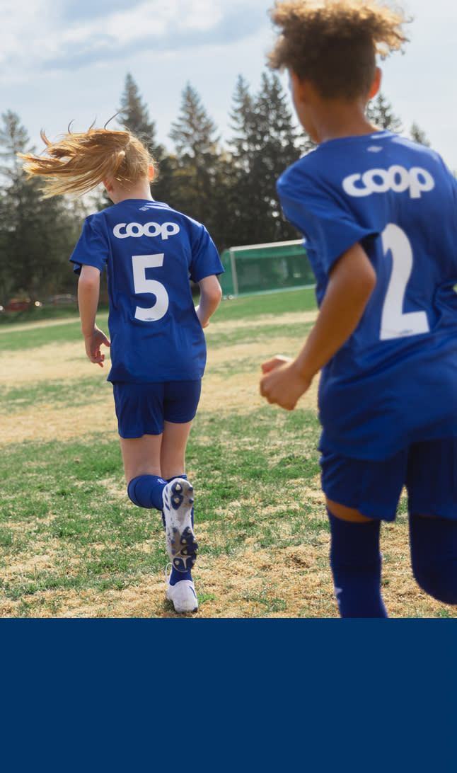 Jenter med Coop drakter løper på en fotballbane